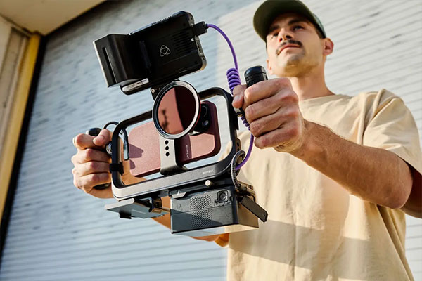 someone holding a phone in a moment cage using two universal mobile grips