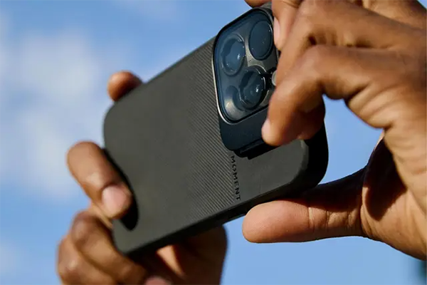 close up of someone taking a photo using a smartphone with the vnd filter attached