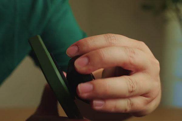 someone attaching a moment mobile lens to a phone