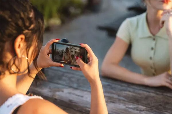 someone taking a photo in the evening using the moment mobile lens