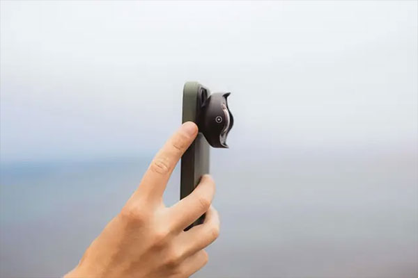 someone holding a smartphone with the moment mobile lens attached
