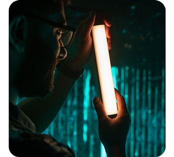 person holding Pavotube ii 6C light tube in dark green room