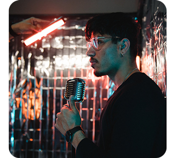 Man standing in reflective room holding vintage microphone lit by pavotube ii 6C