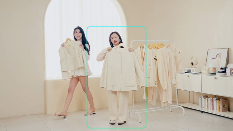 tracking being changed to a different woman on the obsbot ptz camera in a cream studio
