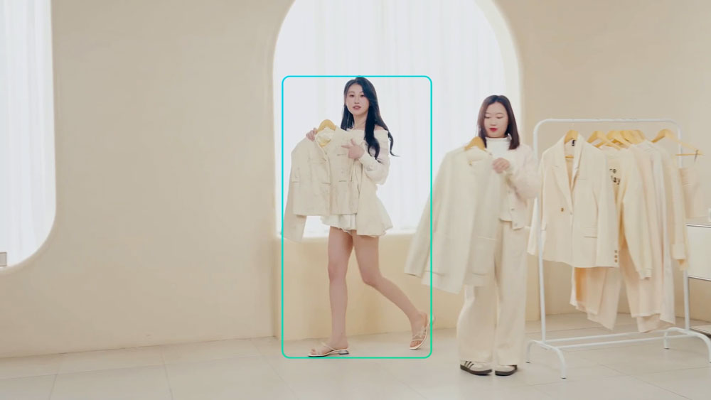 woman being tracked using the only me feature on the obsbot ptz camera in a cream studio