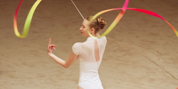 example close up image of a dancer with a yellow and red ribbon