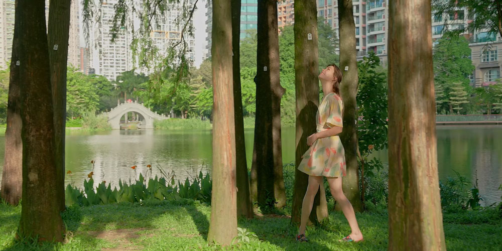 exmple image of a woman walking through some trees near a lake