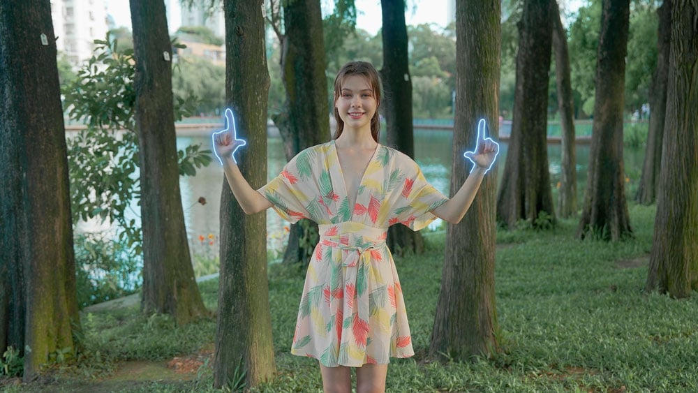 a woman stood near trees using the dynamic zoom gesture