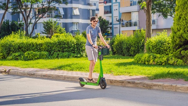 wide zoom of a man on a scooter