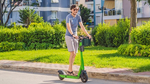 full body zoom of a man on a scooter