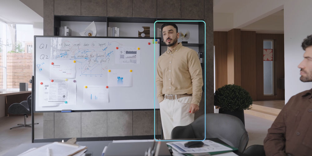 obsbot tiny tracking someone in front of a whiteboard during a business meeting