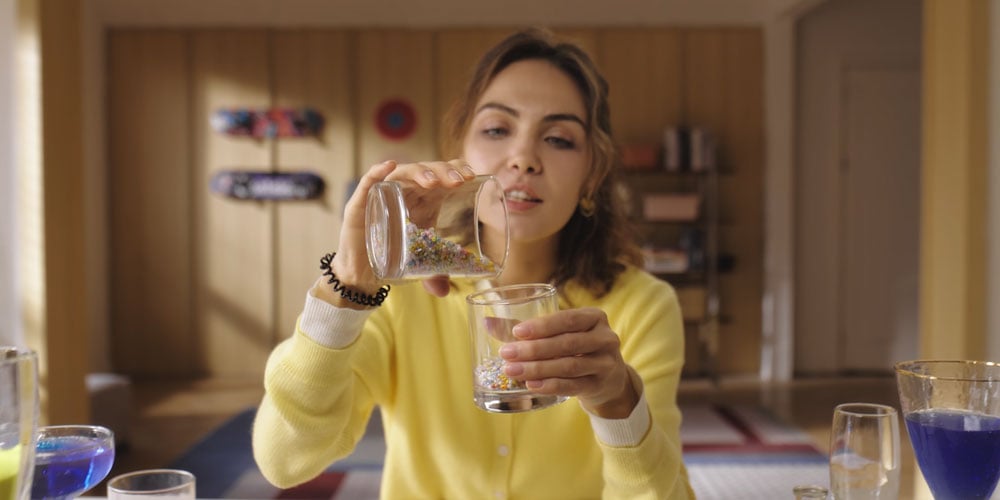 someone pouring beads from one cup to another captured on the obsbot tiny