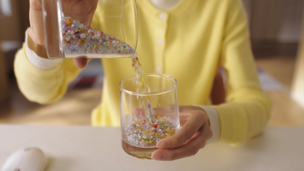 example image from the obsbot tiny of someone pouring beads from one glass to another