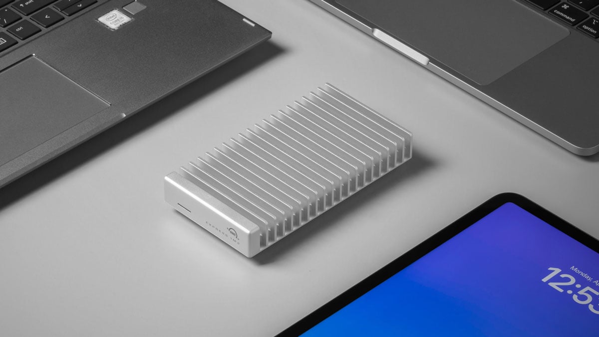 owc ssd enclosure on a grey desk surrounded by compatible devices