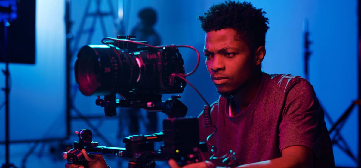 filmaker recording on a blue set lit with red lighting