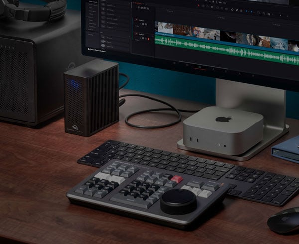 Professional video editing desk setup featuring an Apple Mac Studio, keyboard, and the owc ssd external enclosure