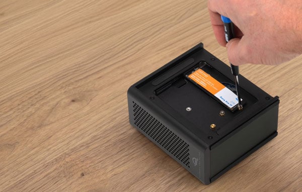 A hand using a screwdriver to install a M.2 NVMe SSD inside the owc ssd enclosure