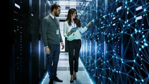 Man and woman walking through server room 