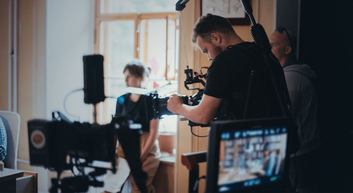 a camera man on set filming using a harness
