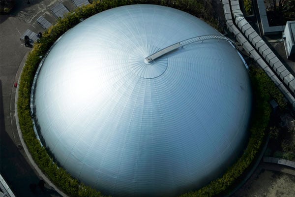 cropped aerial shot of a domed roof building surround by green hedges