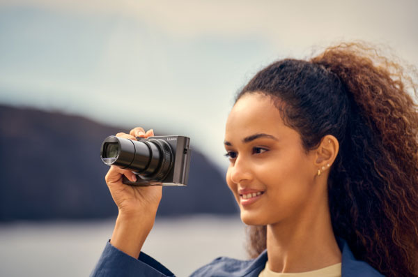 someone taking a photo using the panasonic lumix camera