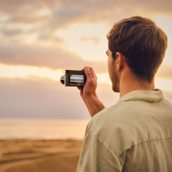 over the shoulder image of someone recording a sunset using the panasonic lumix camera