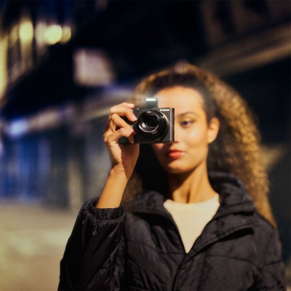 someone taking a photo using the built-in flash on the panasonic lumix camera