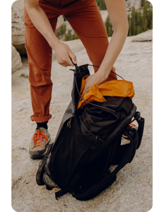 person using Ultra Cinch Roll Top on black Peak Design Outdoor Backpack 