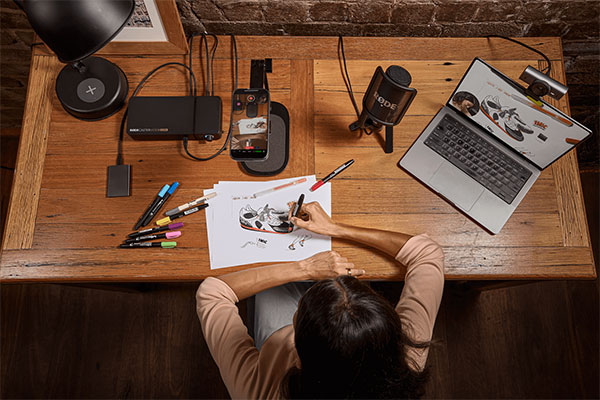 top down view of someone recording using the rodecaster video core while drawing at a wooden desk