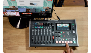 person activating scene preset buttons on Roland VR-6HD mixer