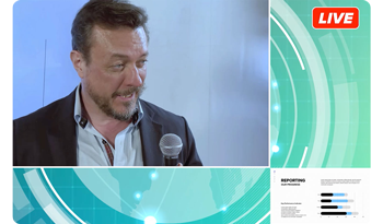 Video still of live broadcast interview with slideshow presentation