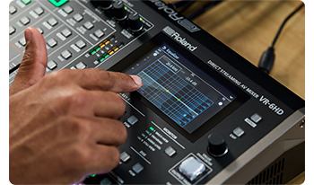 Person adjusting audio EQ with touchscreen on Roland VR-6HD 