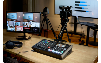Roland VR-6HD panel sat on production table infront of presentation screens 