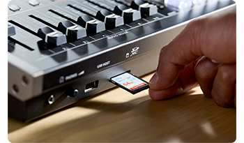 Person inserting SD memory card into storage slot of Roland VR-6HD 