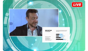 Video still of live broadcast interview with slideshow presentation