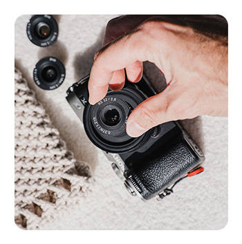 someone attaching the samyang lens to a sony camera