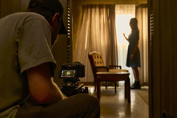 someone recording a woman stood near a open window using the sony fx5