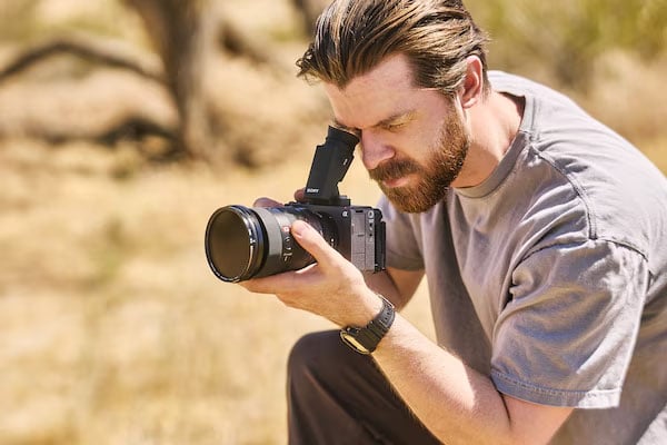 a man crouched down filming using the sony fx5