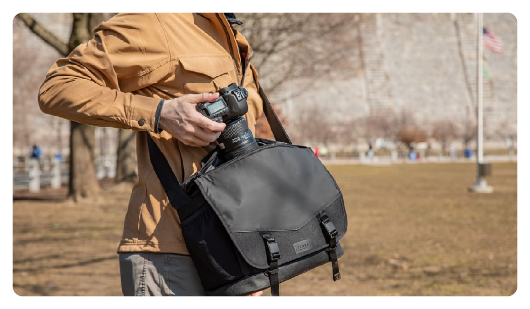 someone taking a camera out of the tenba messenger bag