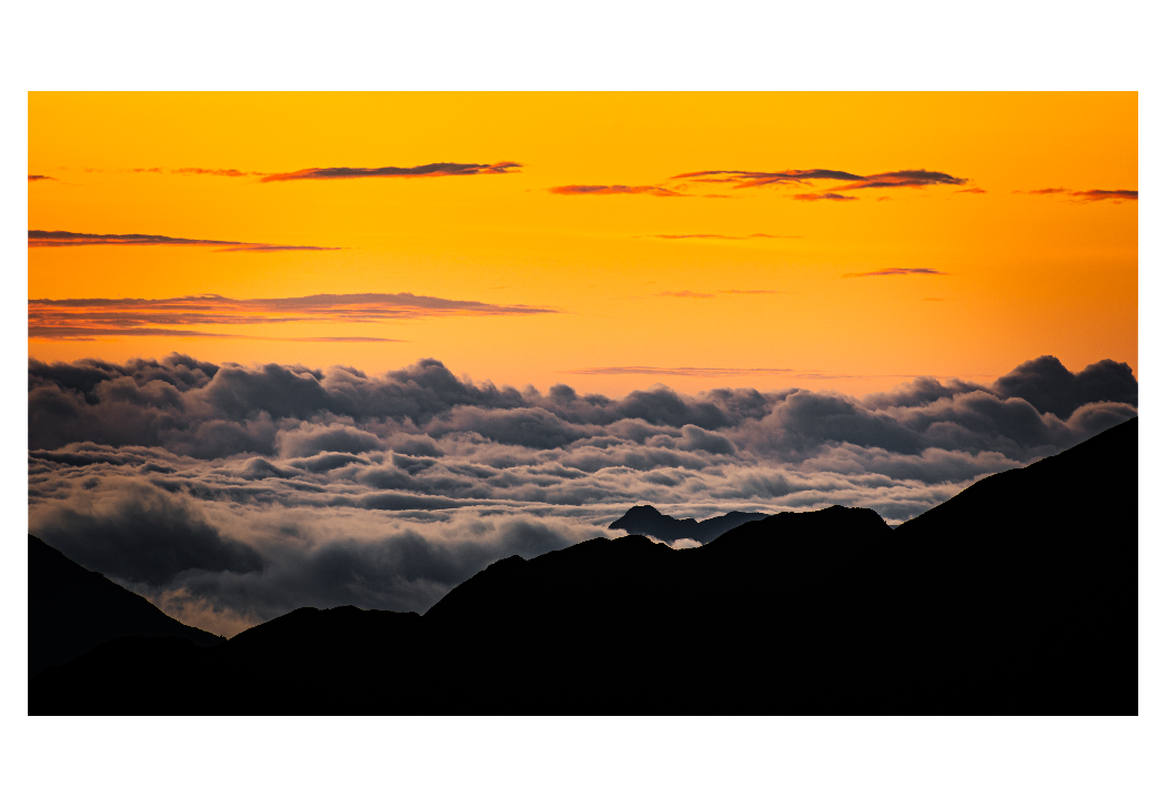 sample image of clouds and an orange sky over a mountain top taken with the ttartisan telephoto lens