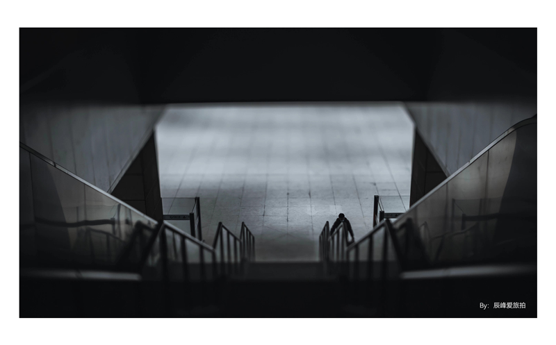 sample black and white photography of man walking up train station triple stairs 
