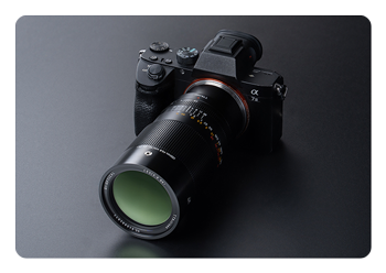 100mm F2.8 Macro X2 Lens attached to a camera on a grey background