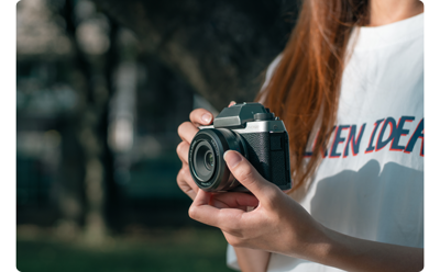 photograph of woman holding Fujifilm X-E4 with TTArtisan AF27mm F2.8 lens