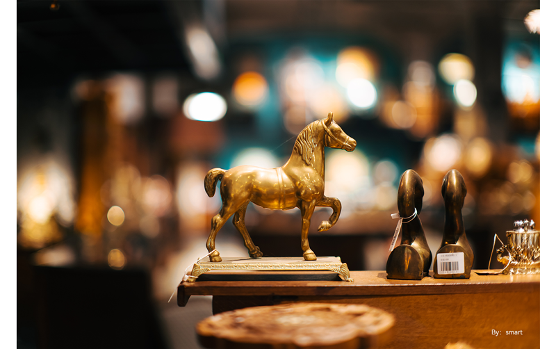 sample photograph of brass horse statue sitting on bar with spherical bokeh background