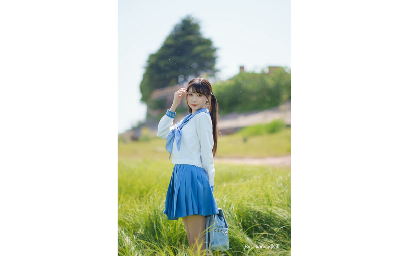sample photograph portrait of asian woman wearing school uniform standing in tall grass field