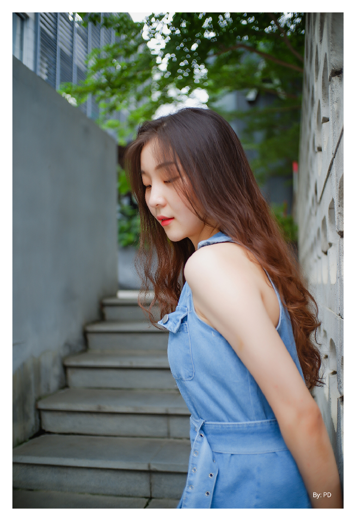 sample image of a woman leaning against a wall in the street taken using the ttartisan 25mm f2