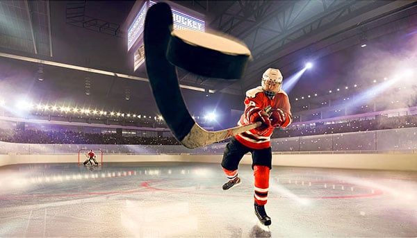 an ice hockey player on a rink taking a shot