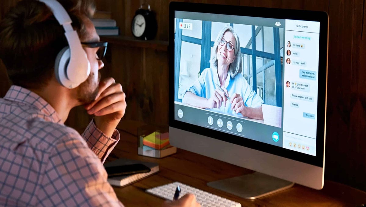 a person wearing headphones and watching an online webinar