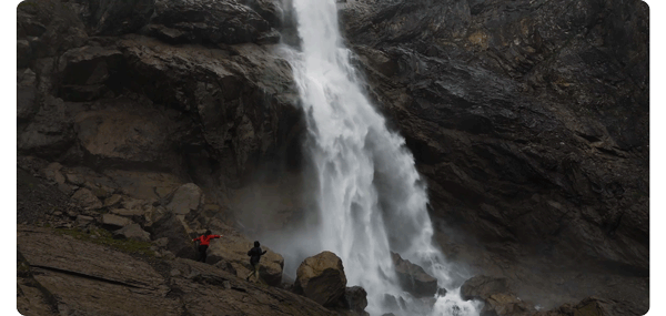 animated gif of two people stood infront of a roaring waterfall