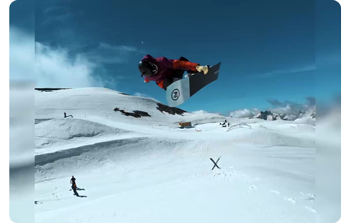 Still image of snowboarder mid grab trick flying through the air in 4:3 aspect ratio